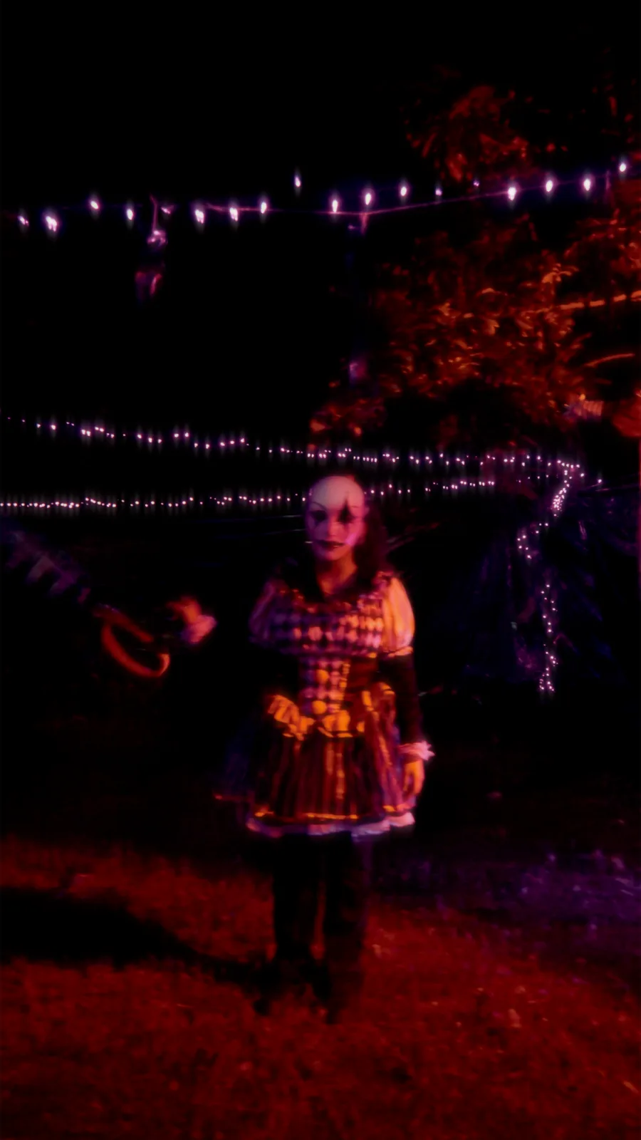 A full-length costumed scare actor standing on the night trail